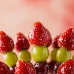 Shiny sugar-coated tanghulu skewers with strawberries and grapes