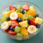 Overhead view of a colorful fruit medley in a white bowl