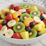Bowl of fresh honey lime fruit salad with vibrant, colorful fruit.