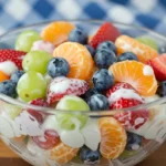 Colorful bowl of Skinny Ambrosia Fruit Salad with grapes, oranges, and creamy yogurt dressing.