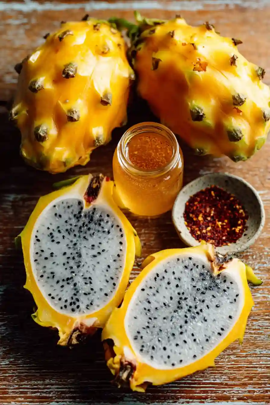 dragon-fruit-salad-ingredients-flatlay_compressed yellow dragon fruits, cara cara orange, lime syrup, and Tajín seasoning ingredients on a wooden surface